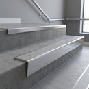 Polished Aluminium raked back aluminium stair nosing 62x55mm with Light Grey Smooth Textured infill, fitted to a concrete step