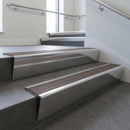 Polished Aluminium raked back aluminium stair nosing 62x55mm with Peat Castellated infill, fitted to a concrete step