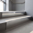 Polished Aluminium raked back aluminium stair nosing 62x55mm with Porth Stone Smooth Textured infill, fitted to a concrete step
