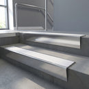 Polished Aluminium raked back aluminium stair nosing 62x55mm with White Castellated infill, fitted to a concrete step