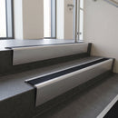 Satin Aluminium raked back aluminium stair nosing 62x55mm with Black Smooth Textured infill, fitted to a concrete step