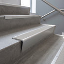 Satin Aluminium raked back aluminium stair nosing 62x55mm with Light Grey Castellated infill, fitted to a concrete step