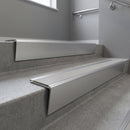 Satin Aluminium raked back aluminium stair nosing 62x55mm with Light Grey Smooth Textured infill, fitted to a concrete step