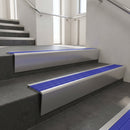 Satin Aluminium raked back aluminium stair nosing 62x55mm with Mid Blue Castellated infill, fitted to a concrete step