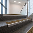 Satin Aluminium raked back aluminium stair nosing 62x55mm with Olive Castellated infill, fitted to a concrete step