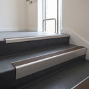 Satin Aluminium raked back aluminium stair nosing 62x55mm with Peat Castellated infill, fitted to a concrete step