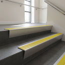 Satin Aluminium raked back aluminium stair nosing 62x55mm with Yellow Castellated infill, fitted to a concrete step