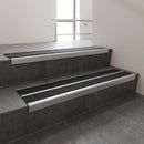 Satin Aluminium raked double channel aluminium stair nosing 90x32mm with Black Olympic Grip infill, fitted to a concrete step