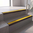 Square edge with ramped back aluminium stair nosing, 70mm tread, brimstone (safety yellow) exterior grip insert, dark bronze finish