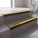 Square edge with ramped back aluminium stair nosing, 70mm tread, brimstone (safety yellow) exterior grip insert, satin black finish
