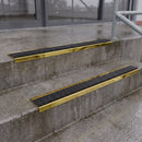 Square edge with ramped back aluminium stair nosing with black gritted exterior grip insert in mirrorflect gold finish fitted on covered external concrete steps