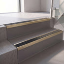 Square edge with ramped back aluminium stair nosing, 70mm tread, obsidian (dark charcoal) Mor Grip insert, satin gold finish