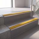 Square edge with ramped back aluminium stair nosing, 70mm tread, solar (golden yellow) Mor Grip insert, mill finish finish