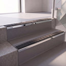 Square edge with ramped back aluminium stair nosing with a dark charcoal Mor Grip insert in bright polished finish fitted on a retail unit stair finished in grey vinyl