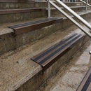 Square edge with ramped back aluminium stair nosing with black gritted exterior grip insert in dark bronze finish fitted on covered external concrete steps
