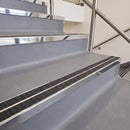 Square edge with ramped back aluminium stair nosing with twin dark charcoal Mor Grip inserts in bright polished finish fitted on a leisure centre stair finished in grey safety vinyl
