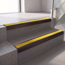Square edge with ramped back aluminium stair nosing, 70mm tread, brimstone (safety yellow) exterior grip insert, dark bronze finish