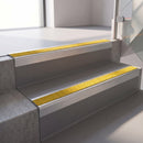 Square edge with ramped back aluminium stair nosing, 70mm tread, brimstone (safety yellow) exterior grip insert, mill finish finish