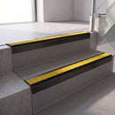 Square edge with ramped back aluminium stair nosing, 70mm tread, brimstone (safety yellow) exterior grip insert, satin black finish