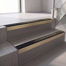 Square edge with ramped back aluminium stair nosing, 70mm tread, coal (black) exterior grip insert, satin gold finish