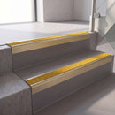 Square edge with ramped back aluminium stair nosing, 70mm tread, solar (golden yellow) Mor Grip insert, satin gold finish