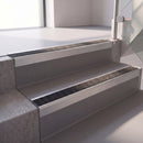 Square edge with ramped back aluminium stair nosing with a dark charcoal Mor Grip insert in mill finish finish fitted on a hospital entrance stair finished in grey safety vinyl
