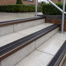 Ramp back twin channel aluminium stair nosing 93 x 38mm in Dark Bronze with two Coal gritted Exterior Grip inserts, fitted on wet outdoor entrance steps