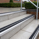 Ramp back twin channel aluminium stair nosing 93 x 38mm in Mill Finish with two Coal gritted Exterior Grip inserts, fitted on wet outdoor entrance steps