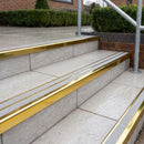 Ramp back twin channel aluminium stair nosing 93 x 38mm in Mirrorflect Gold with two Everest gritted Exterior Grip inserts, fitted on wet outdoor entrance steps