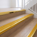 Ramp back twin channel aluminium stair nosing 93 x 38mm in Mirrorflect Gold with two Solar textured High Grip inserts, fitted on an indoor oak-effect vinyl staircase