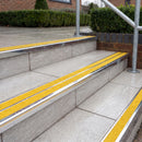 Ramp back twin channel aluminium stair nosing 93 x 38mm in Mirrorflect Silver with two Brimstone gritted Exterior Grip inserts, fitted on wet outdoor entrance steps