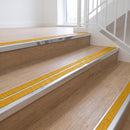 Ramp back twin channel aluminium stair nosing 93 x 38mm in Mirrorflect Silver with two Solar textured High Grip inserts, fitted on an indoor oak-effect vinyl staircase