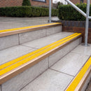 Ramp back twin channel aluminium stair nosing 93 x 38mm in Satin Bronze with two Brimstone gritted Exterior Grip inserts, fitted on wet outdoor entrance steps