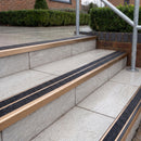 Ramp back twin channel aluminium stair nosing 93 x 38mm in Satin Bronze with two Coal gritted Exterior Grip inserts, fitted on wet outdoor entrance steps