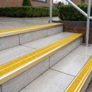 Ramp back twin channel aluminium stair nosing 93 x 38mm in Satin Gold with two Brimstone gritted Exterior Grip inserts, fitted on wet outdoor entrance steps