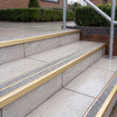 Ramp back twin channel aluminium stair nosing 93 x 38mm in Satin Gold with two Everest gritted Exterior Grip inserts, fitted on wet outdoor entrance steps