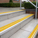 Ramp back twin channel aluminium stair nosing 93 x 38mm in Satin Silver with two Brimstone gritted Exterior Grip inserts, fitted on wet outdoor entrance steps