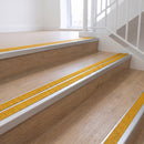Ramp back twin channel aluminium stair nosing 93 x 38mm in Satin Silver with two Solar textured High Grip inserts, fitted on an indoor oak-effect vinyl staircase