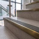 Antique brass ramped stair nosing with speckled graphite carborundum insert fitted to concrete steps