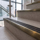 Antique brass ramped stair nosing with speckled obsidian carborundum insert fitted to concrete steps