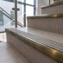 Antique brass ramped stair nosing with speckled pebble carborundum insert fitted to concrete steps