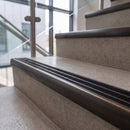 Antique bronze ramped stair nosing with obsidian carborundum insert fitted to concrete steps