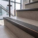 Antique bronze ramped stair nosing with speckled graphite carborundum insert fitted to concrete steps