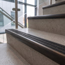Antique bronze ramped stair nosing with speckled obsidian carborundum insert fitted to concrete steps