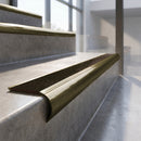 Antique Brass finish - solid brass raked back stair nosing with CarbiGrip - Chestnut insert fitted on concrete steps