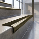 Antique Brass finish - solid brass raked back stair nosing with CarbiGrip - Hazelnut insert fitted on concrete steps