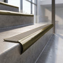 Antique Brass finish - solid brass raked back stair nosing with CarbiGrip - Portland Stone insert fitted on concrete steps