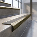 Antique Brass finish - solid brass raked back stair nosing with Ridged PVC - Fog insert fitted on concrete steps