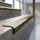 Antique Brass finish - solid brass raked back stair nosing with Ridged PVC - Snow insert fitted on concrete steps