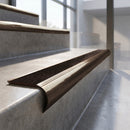 Antique Bronze finish - solid brass raked back stair nosing with CarbiGrip - Chestnut insert fitted on concrete steps